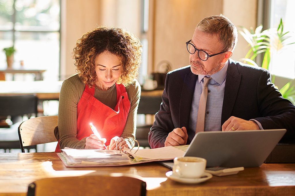 Accountant sitting next to business owner reviewing year end tax planning business